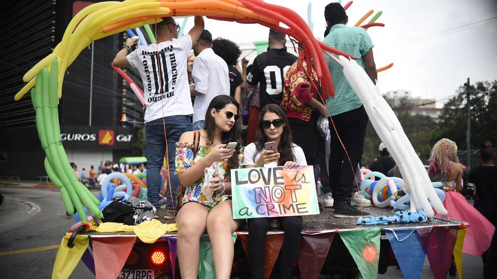 Pridefirare tog sig genom Guatemala City på regnbågsutsmyckade bilar.