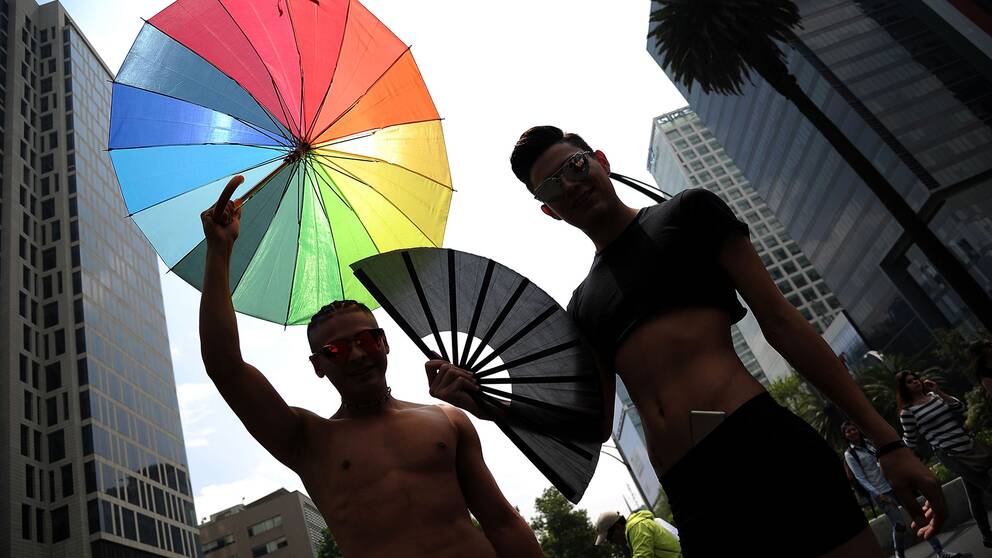 Pride-firare tar skydd från solen i Mexico City.