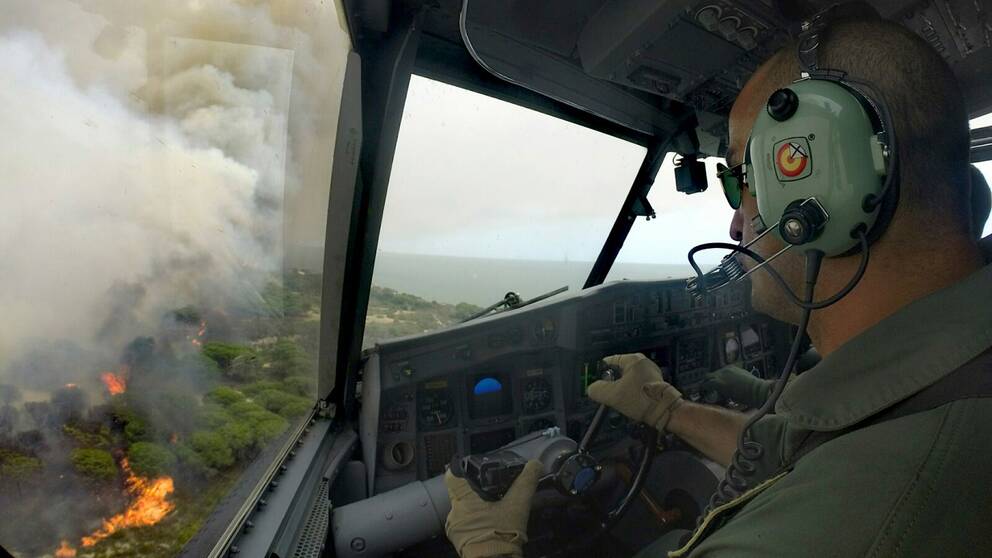 Ett spanskt brandflygplan flyger över skogsbranden i södra Spanien.