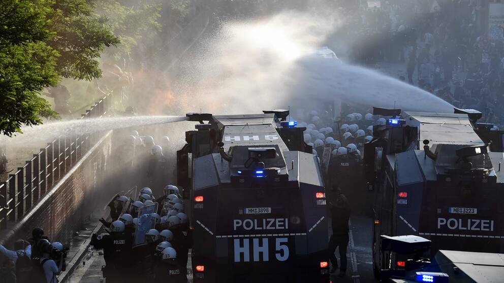 Polisen sprutar vatten på demonstranterna.