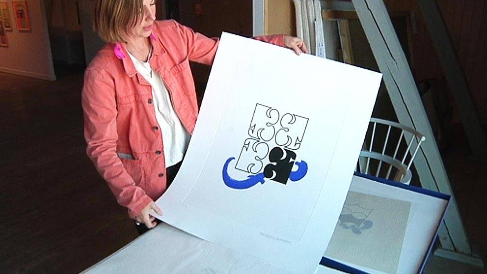 En kvinna visar en målning