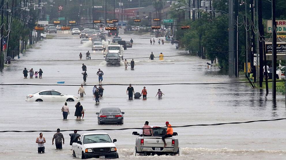 Människor vadar fram på Telephone road i södra Houston. Staden, som är USA:s fjärde folkrikaste, har drabbats av massiva översvämningar de senaste dygnen.