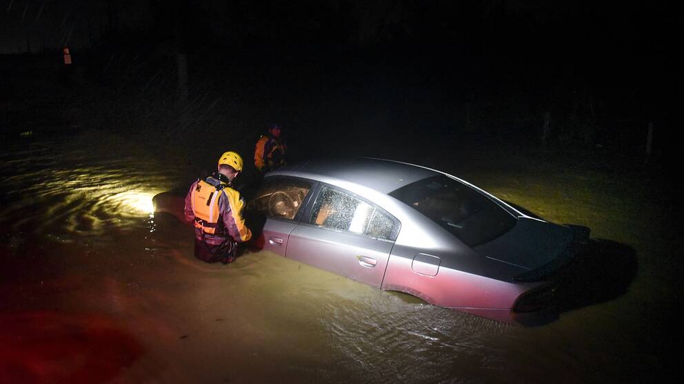 Räddningstjänsten undersöker en bil som fastnat i vattenmassorna i Fajardo i Puerto Rico. 