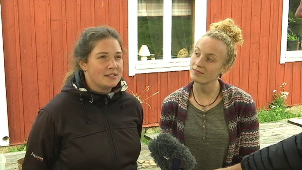 två tjejer framför falurött hus