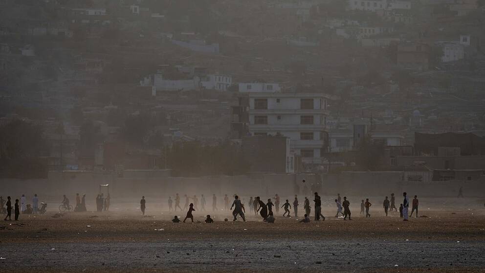 Afghan youths play football in a field at Shuda Lake in Kabul on October 20, 2017. / AFP PHOTO / WAKIL KOHSAR