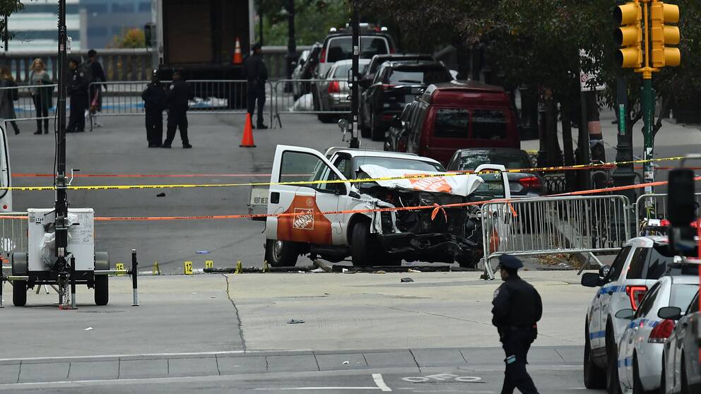 A police offier walks past the wreckage of a Home Depot pickup truck, a day after it was used in an terror attack, in New York on November 1, 2017. The pickup truck driver who plowed down a New York cycle path, killing eight people, in the city's worst attack since September 11, was associated with the Islamic State group but ”radicalized domestically,” the state's governor said Wednesday. The driver, identified as Uzbek national named Sayfullo Saipov was shot by police in the stomach at the end of the rampage, but he was expected to survive. / AFP PHOTO / Jewel SAMAD