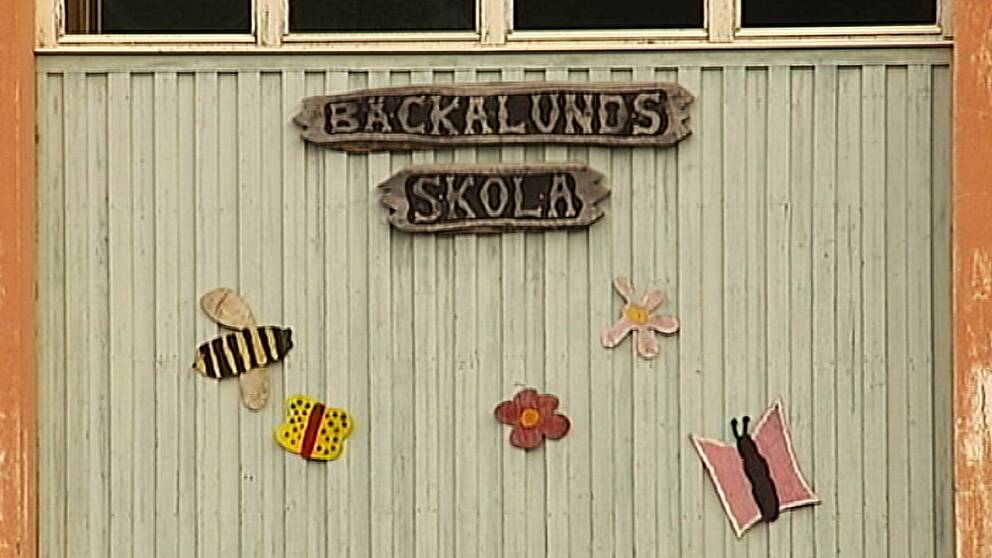 En vägg med en skylt där det står Bäckalunds skola