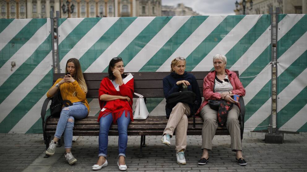 En grupp kvinnor sitter på en bänk i centrala delarna av Moskva, Ryssland. 