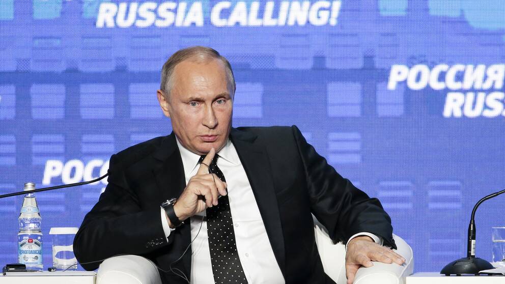 Rysslands president Vladimir Putin sitter i en stol och talar.