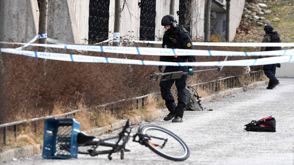 Polisen undersöker det avspärrade området. En man i 60-årsåldern avled och en kvinna i 45-årsåldern skadades i en explosion vid tunnelbanestationen Vårby Gård utanför Stockholm.
