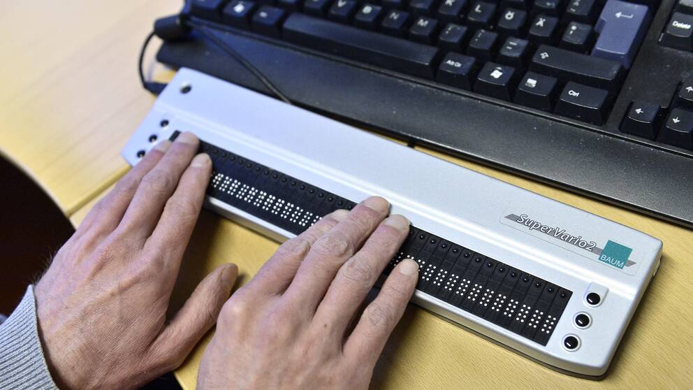En synskadad man skriver på sin skärmläsare till sin dator.