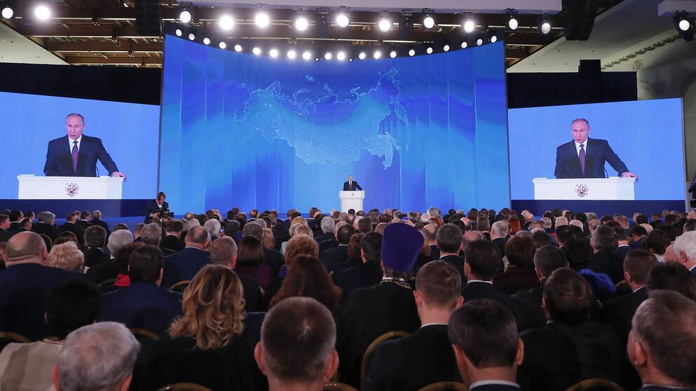 Rysslands president Vladimir Putin håller tal inför en stor publik.