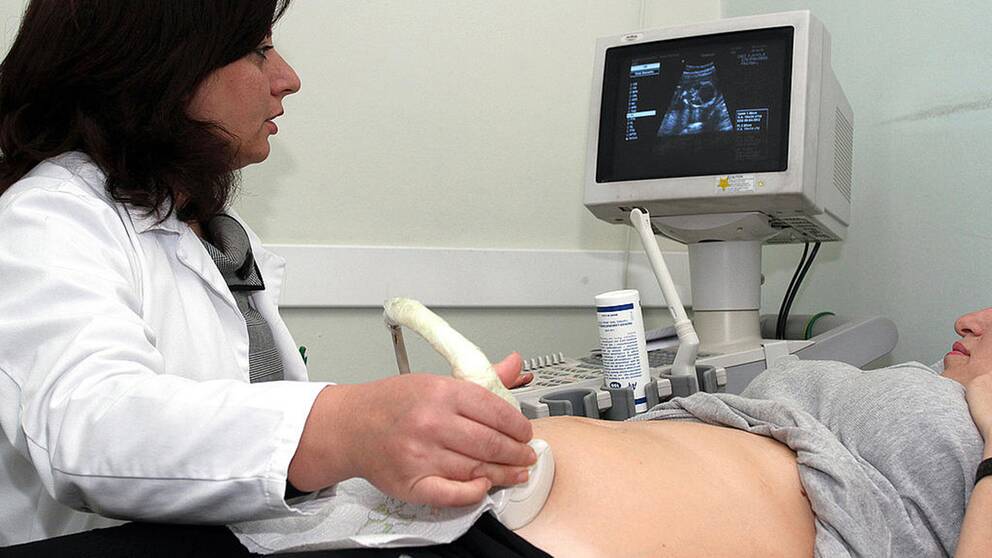 Läkare som genomför ett ultraljud på en kvinnlig patient.