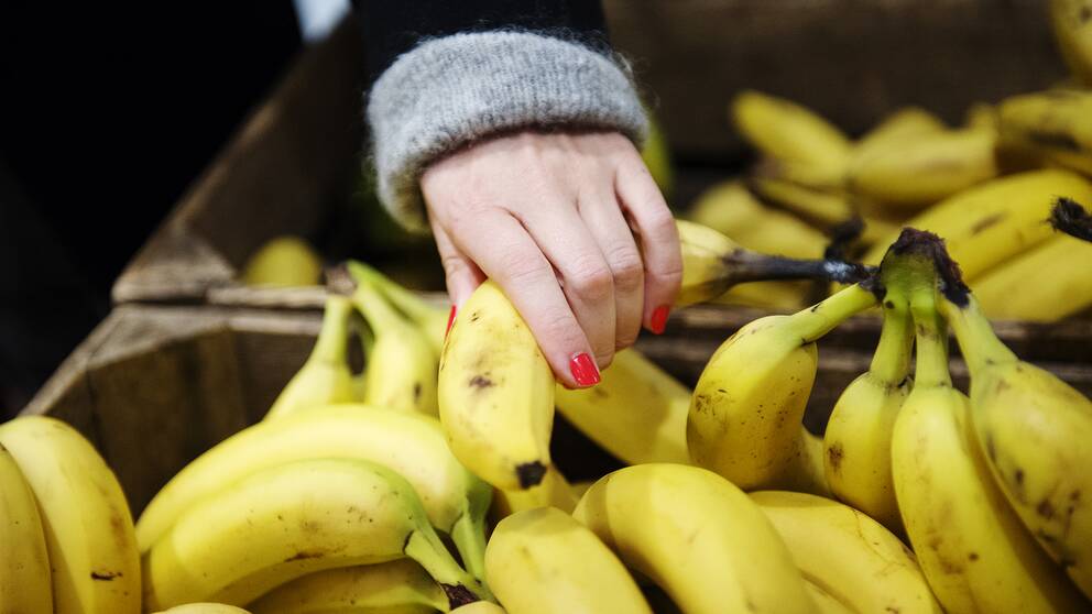 En hand som tar i en banan.