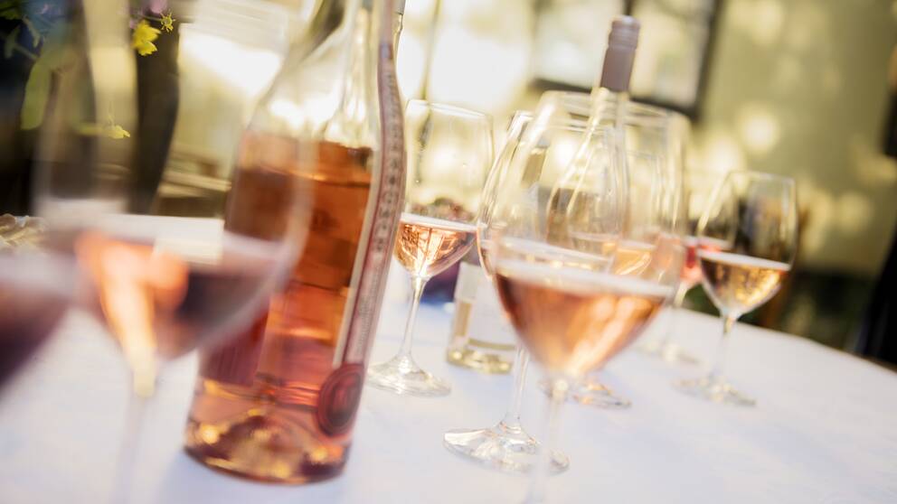 Två flaskor rosévin och halvfulla glas framdukade på ett vit bord