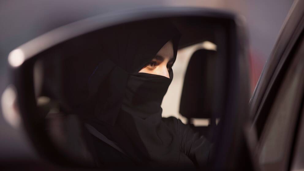 I backspegeln till en bil syns en kvinna bakom ratten i Saudiarabien.