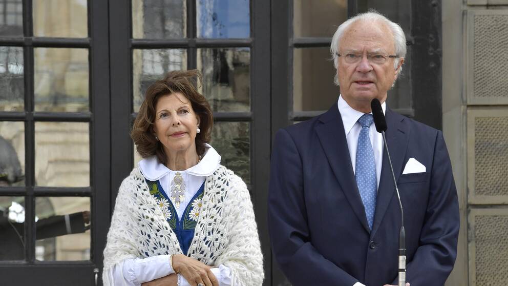 Kung Carl Gustaf håller tal och drottning Silvia ser på, på borggården på Stockholm slott vid nationaldagsfirandet
