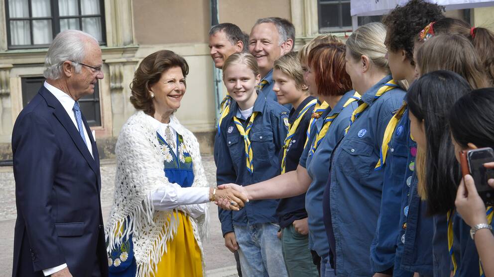 Kung Carl Gustaf och drottning Silvia hälsar på medlemmar ur Bergshamra scoutkår, under nationaldagsfirandet på Stockholms slott. 
