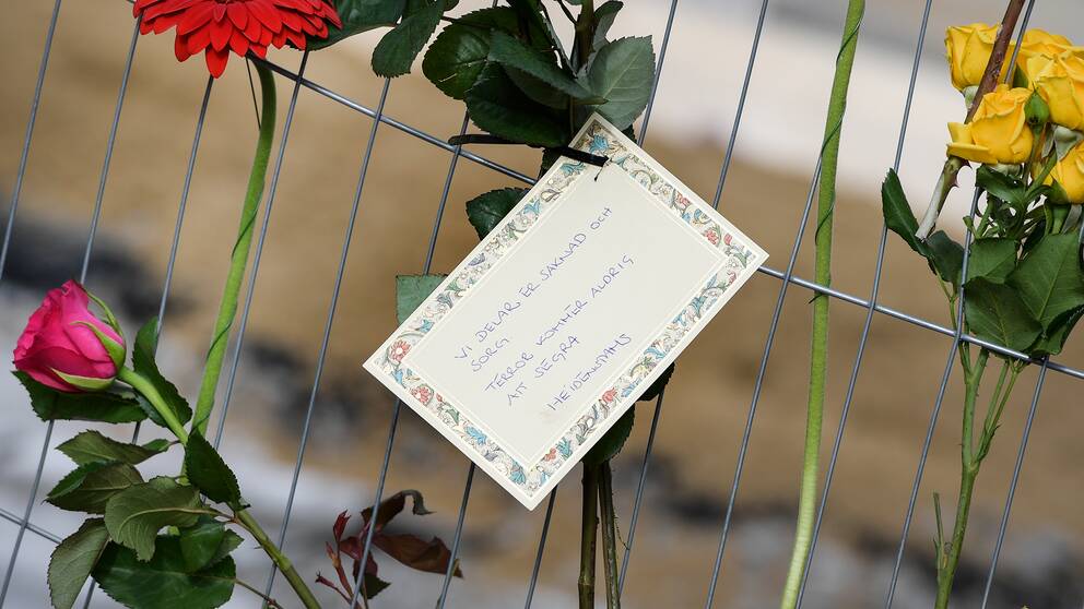 Blommor och ett kort med texten ”Vi delar er saknad och sorg. Terror kommer aldrig att segra. Heidenstams”