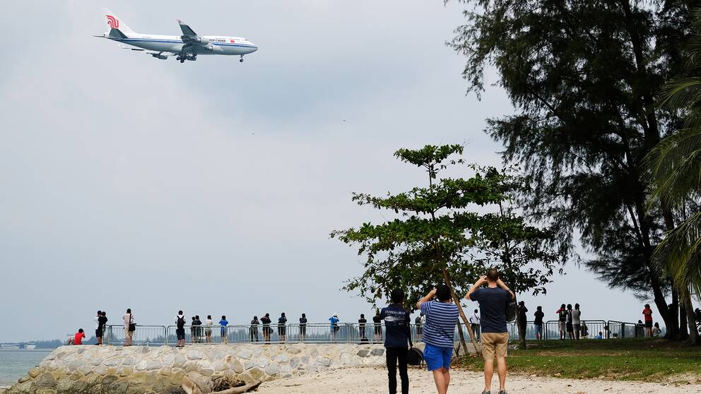 Människor fotar det flygplan som Kim Jong-Un anländer med i Singapore. 