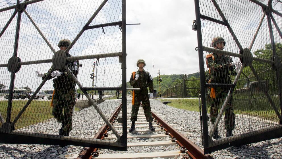 Sydkoreanska soldater öppnar en grind i den demilitariserade zonen för att släppa igenom ett nordkoreanskt tåg. Arkivbild.