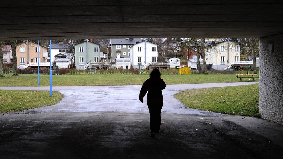 Bild på en kvinna som promenerar i en tunnel.