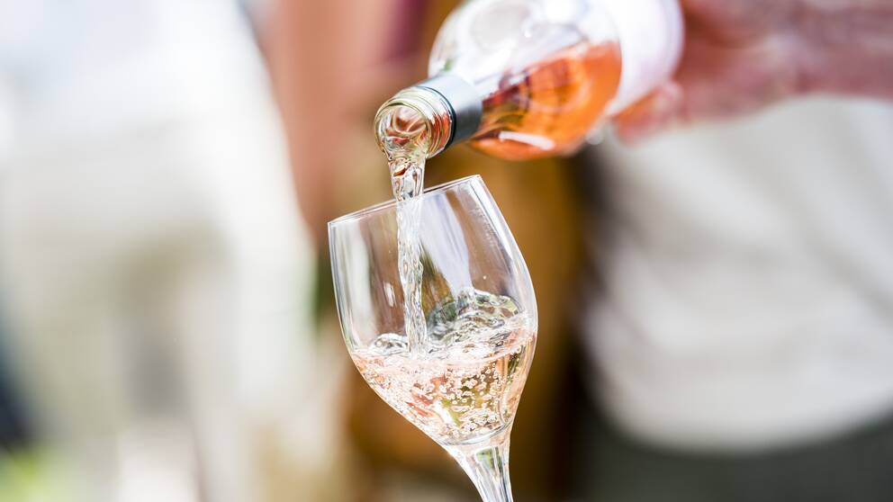 Glas som fylls med rosévin.