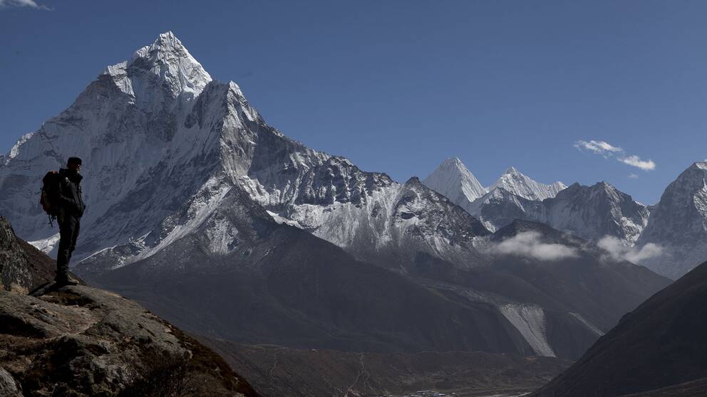 En klättrare tar en paus på väg upp på Mount Everest och tittar på utsikten.
