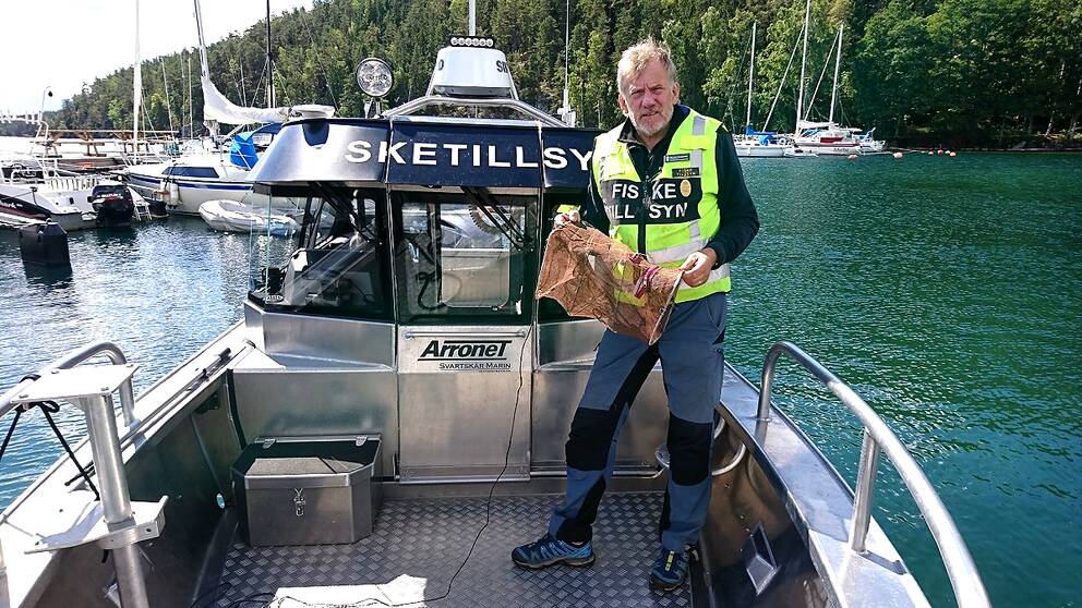 fisketillsynsman på båt i hamn