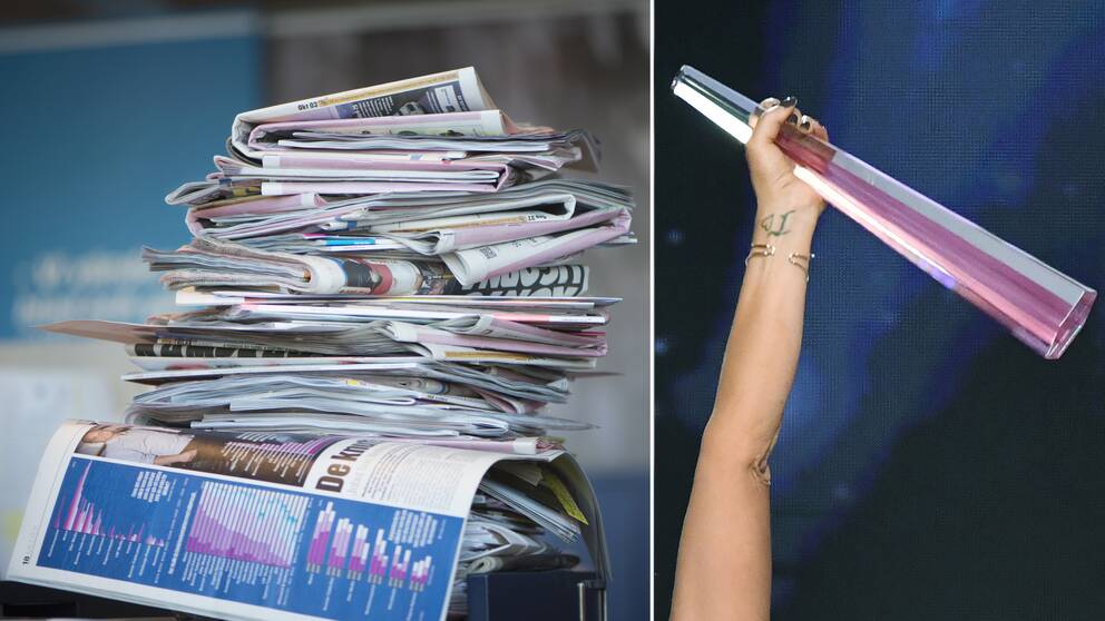 En tidningshög och en statyett som hålls upp av en hand.