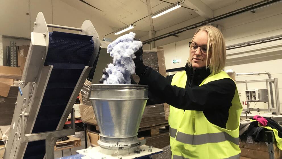 Projektledaren Alicia Björklund kör ner de söndermalda handdukarna i formeringsmaskinen.