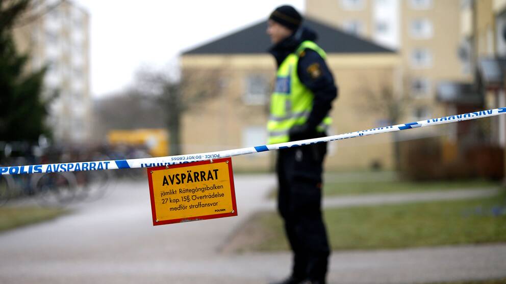 En polis vid en plats där en man sköts till döds av polis