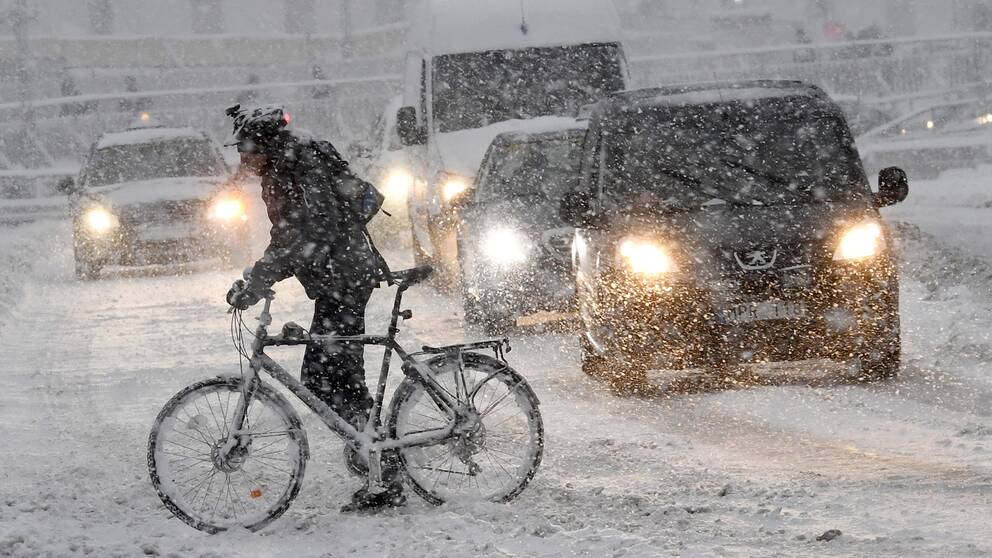 En cyklist på på en snöfylld gata.