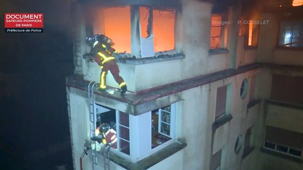 Brandmän klättrar på stegar för att nå de utsatta lägenheterna