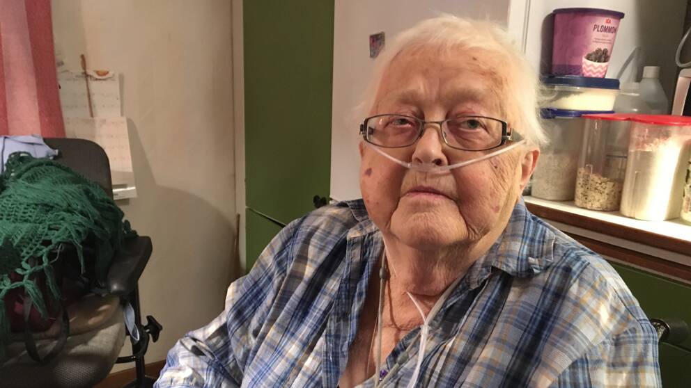 Äldre kvinna, Margon Landgren i Rossön, sitter med syrgas vid sitt köksbord