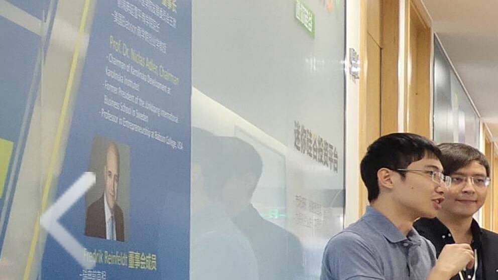 På en vägg i Kevin Lius bolag MiniSV i Nanjing i Kina finns en bild av Fredrik Reinfeldt som har arbetat som konsult i Niclas Adlers bolag NGT.