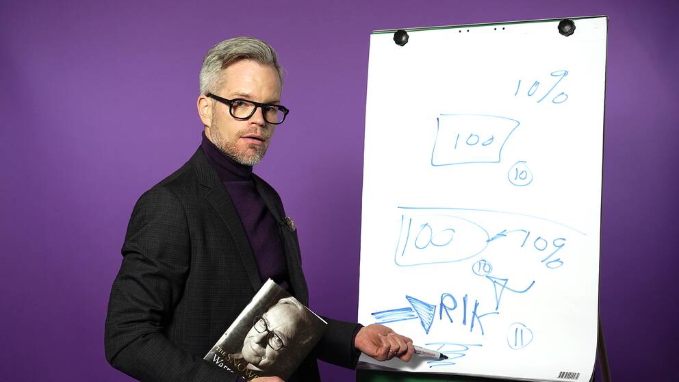 Alexander Norén framför vit tavla med bok.