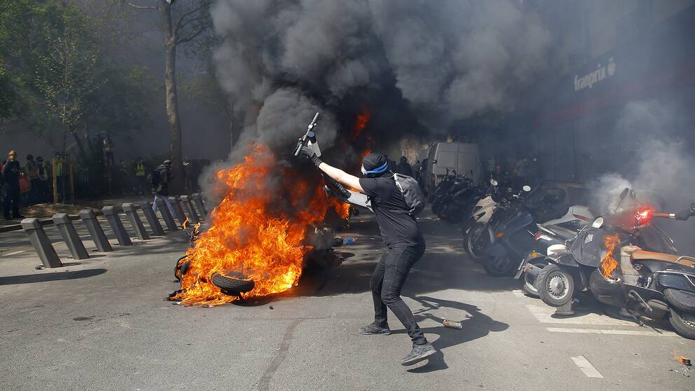 En demonstrant vid ett moln av röd och eld.