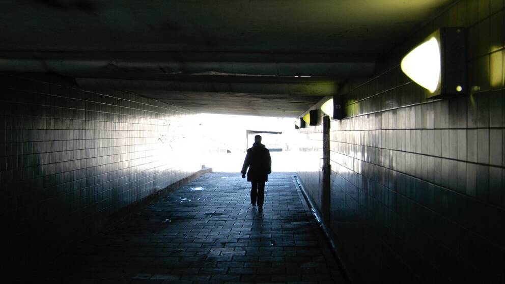 En människa går genom en mörk tunnel.