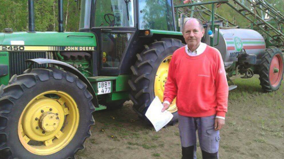 Kent Eriksson framför sina gröna traktor