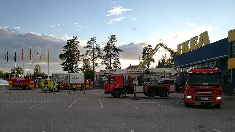 brandbilar och ambulans på parkeringen vid Ikea i Valbo, stege upp mot taket.