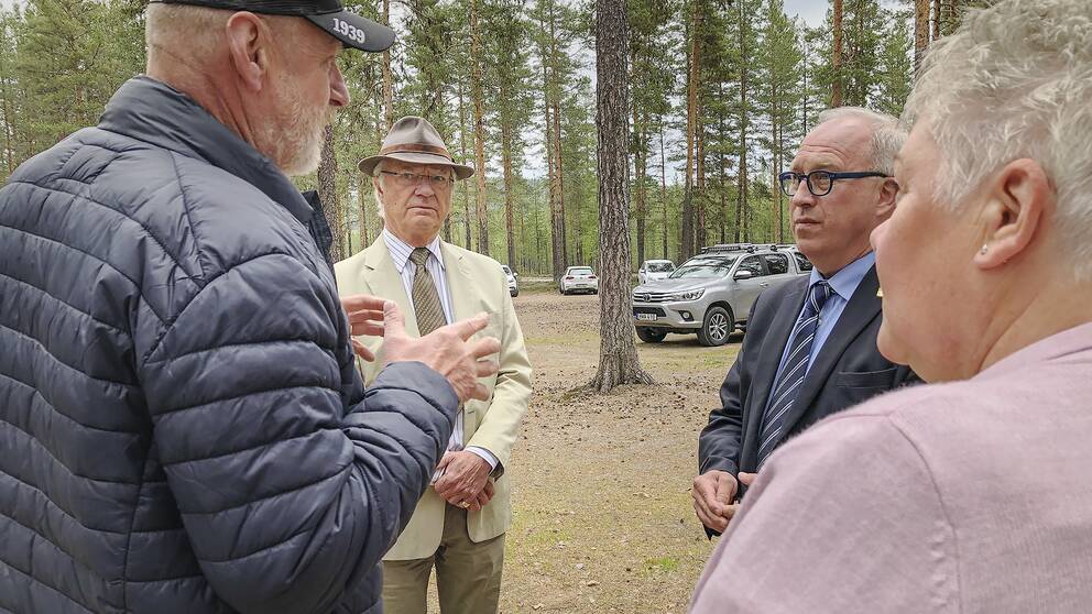 Kung Carl Gustaf samtalar med Per Bill och två boende i brandområdet i Kårböle.