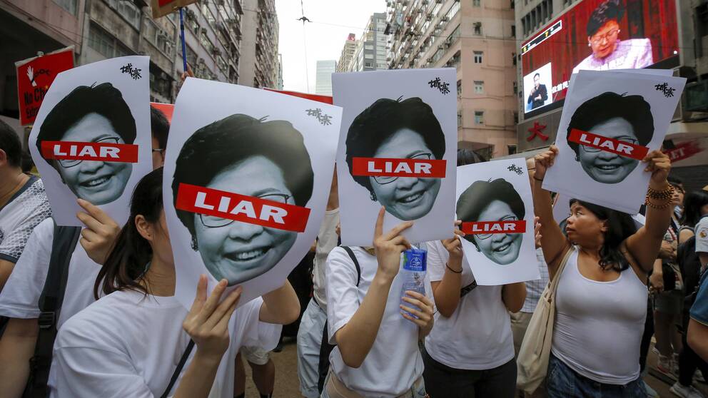 Demonstranter med plakat föreställande Hongkongs ledare Carrie Lam under söndagens protester.