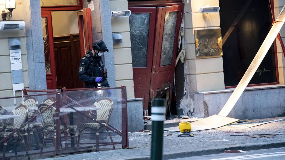 En polis utanför en byggnad som har skadats i en explosion