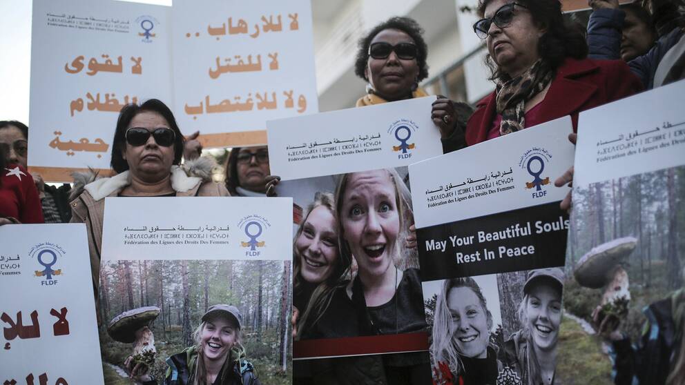 Marockanska kvinnor som håller upp bilder på de två skandinaviska kvinnorna som mördades.