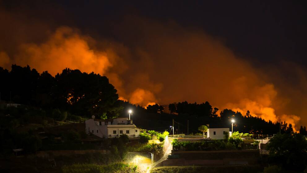 Lågor och rök från skogsbränderna. Här utanför byn Vallseco.