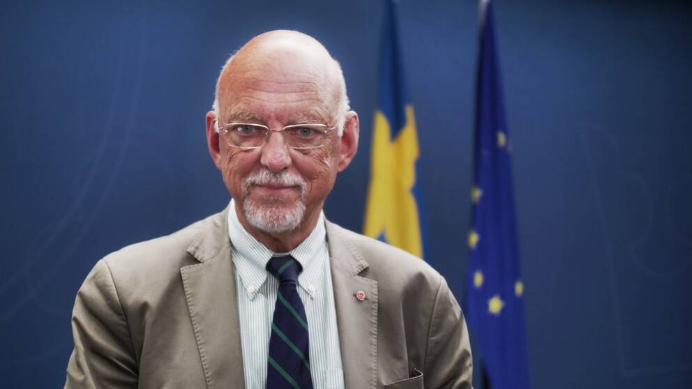 Hans Dahlgren står framår svenska flaggan och EU-flaggan