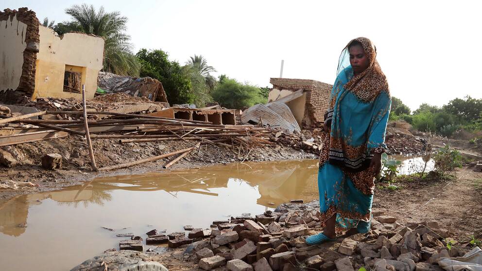 En sudanesisk kvinna i staden Geli, fyra mil norr om huvudstaden Khartoum, kliver runt bland bråte från byggnader som förstörts efter att en kraftig störtflod dragit fram.