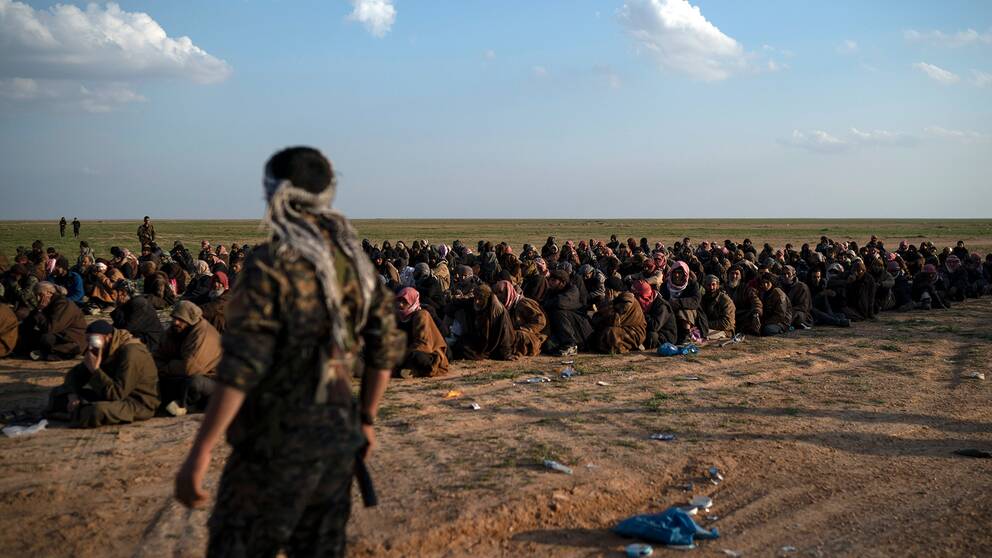 Bild på tillgångatagna män från IS sista fäste i Baghouz i östra Syrien.