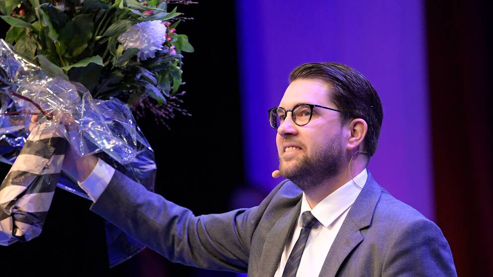 Jimmie Åkesson, Sverigedemokraternas partiledare håller i en blomma. 